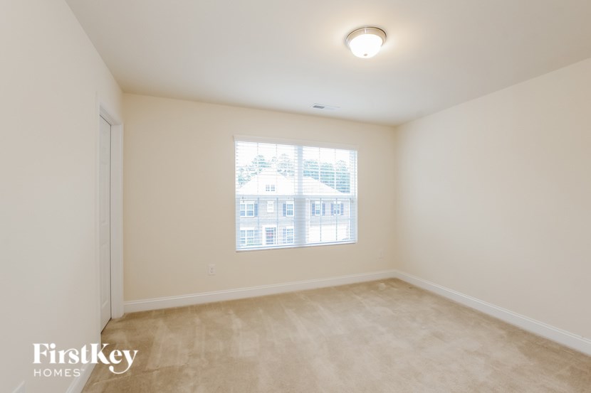 A room with a window showing a building outside.