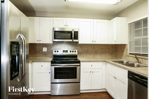 a kitchen with stainless steel appliances and white cabinets