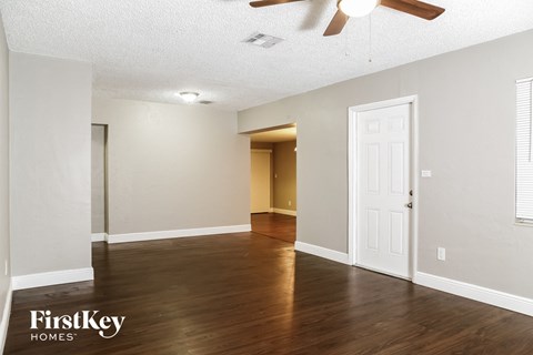the living room and dining room with hardwood flooring and a ceiling fan
