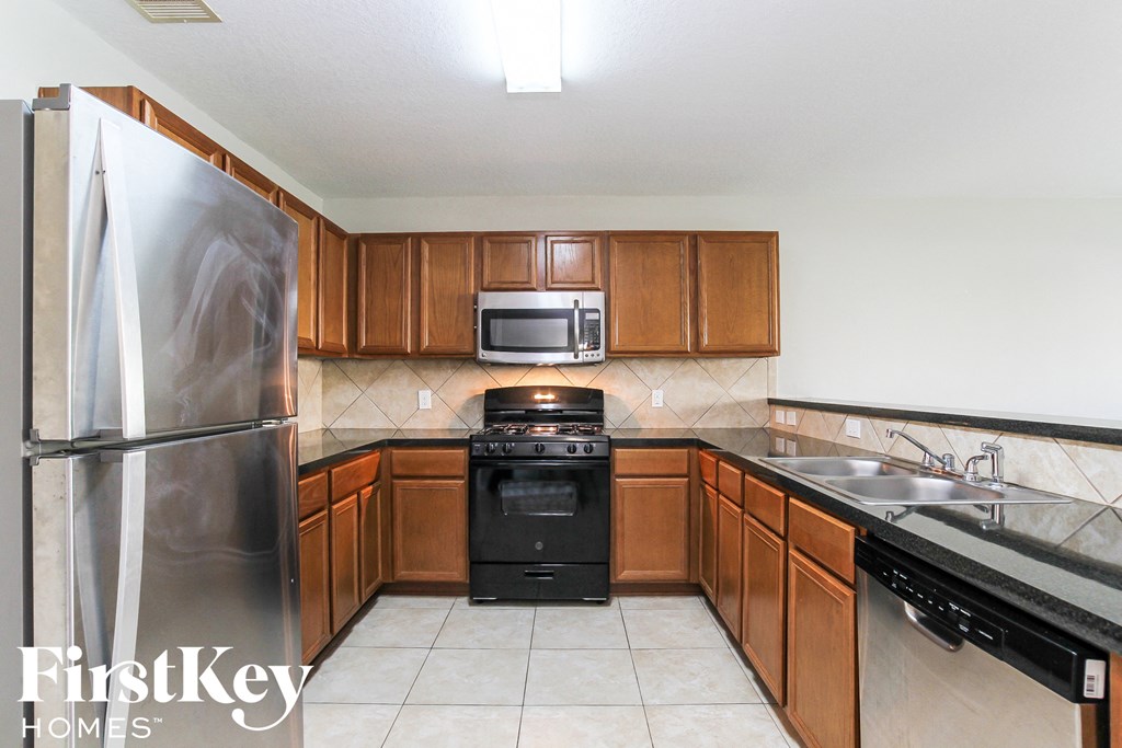 a kitchen with wooden cabinets and stainless steel appliances