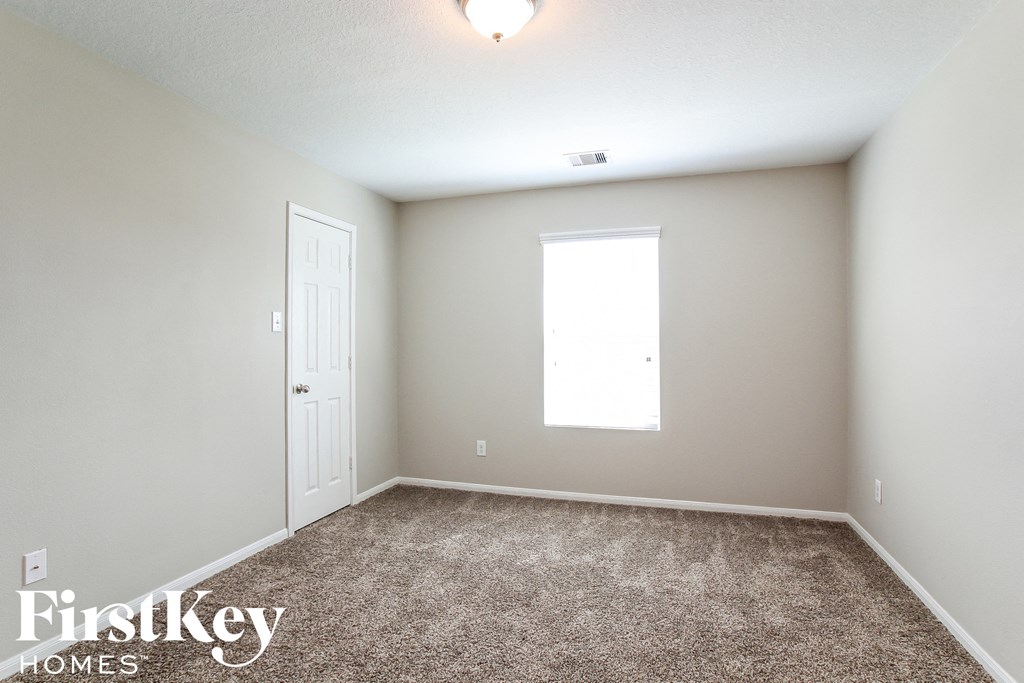 a bedroom with a carpeted floor and a white door