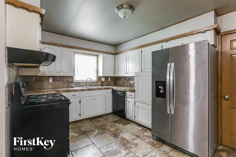 A kitchen with a stove top oven and a refrigerator.