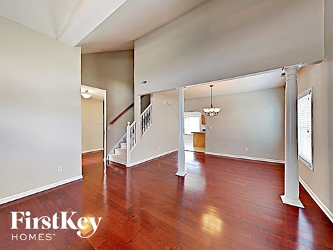 an empty living room with wood floors and a staircase