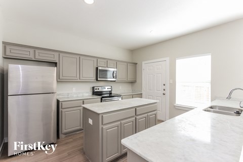 a kitchen with white marble counter tops and stainless steel appliances