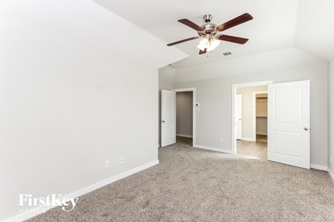 a living room with carpet and a ceiling fan
