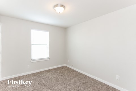 a bedroom with a carpeted floor and a window