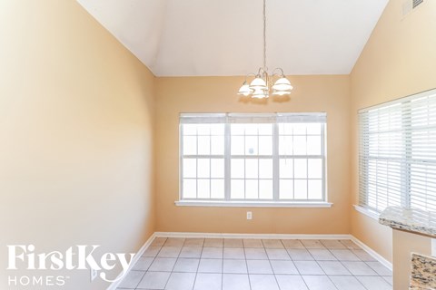 a dining room with a large window and a tile floor