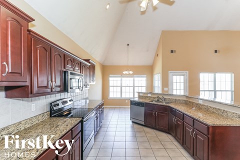 a large kitchen with granite counter tops and wooden cabinets