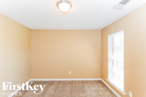 a bedroom with a carpeted floor and a large window