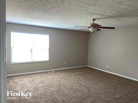 A room with a ceiling fan and a window.
