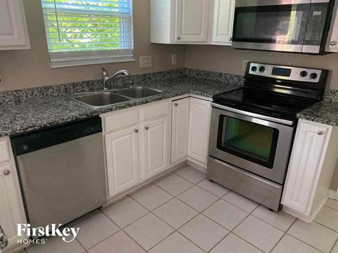 A kitchen with a stove top oven and a sink.