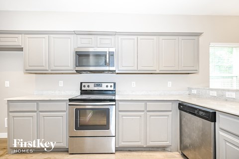 A kitchen with a stove top oven and microwave above it.