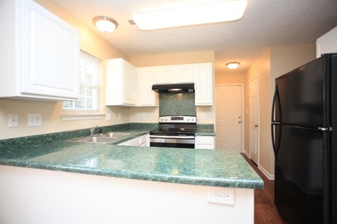 a kitchen with black appliances and green counter tops