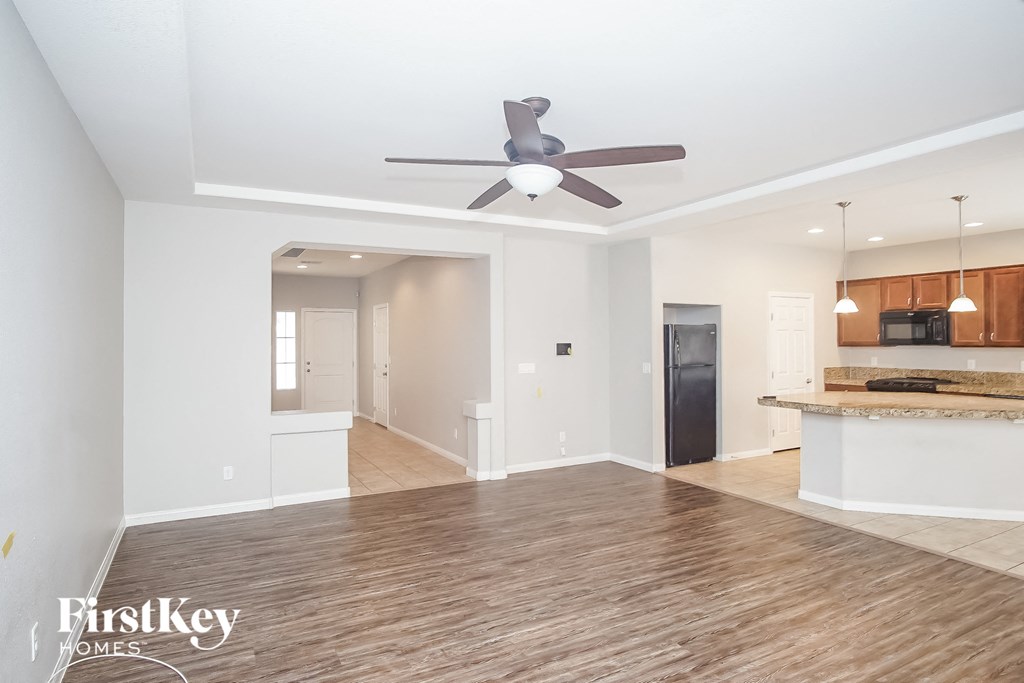 an open living room and kitchen with a ceiling fan