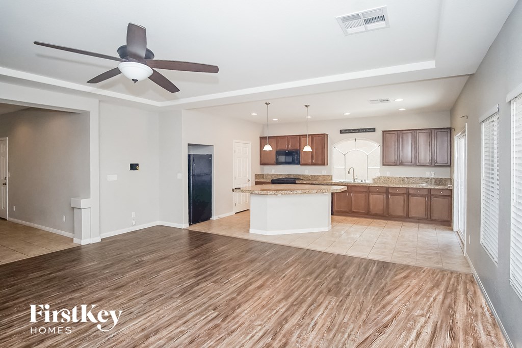 an open kitchen and living room with a ceiling fan