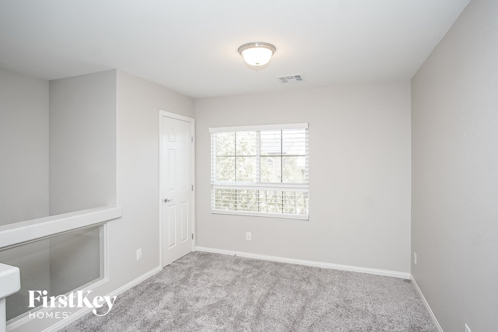 a bedroom with carpeted flooring and a window