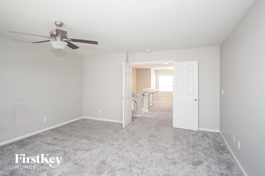 a living room with carpet and a ceiling fan