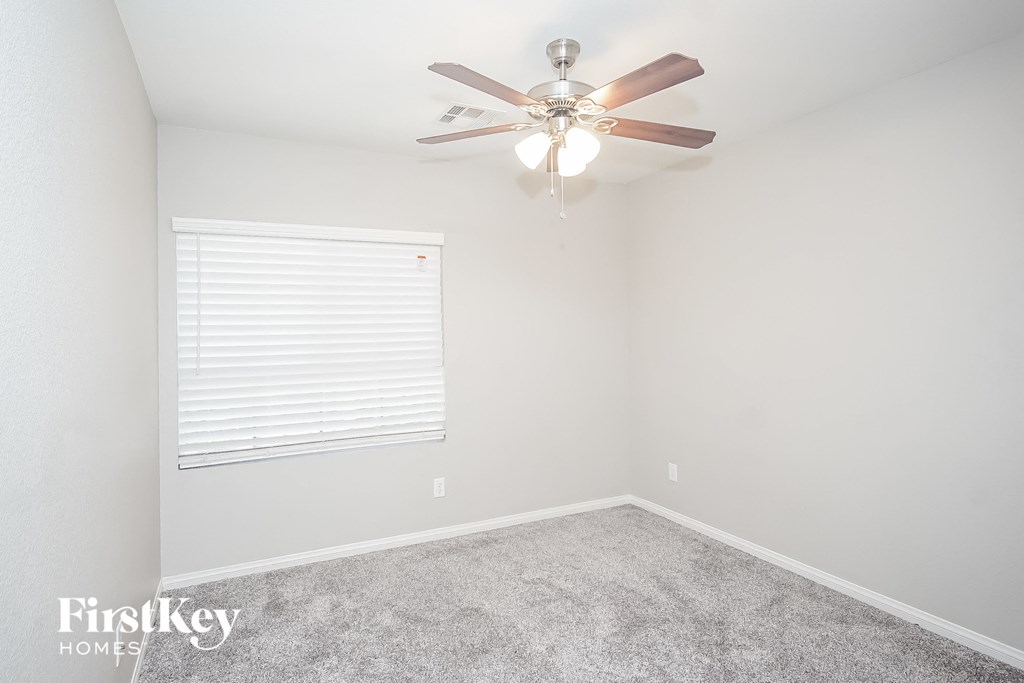 a bedroom with a ceiling fan and a window