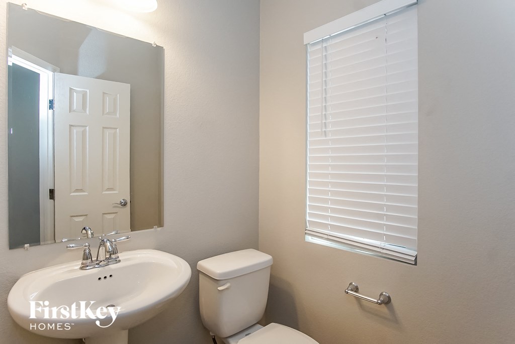 a bathroom with a sink and toilet and a mirror