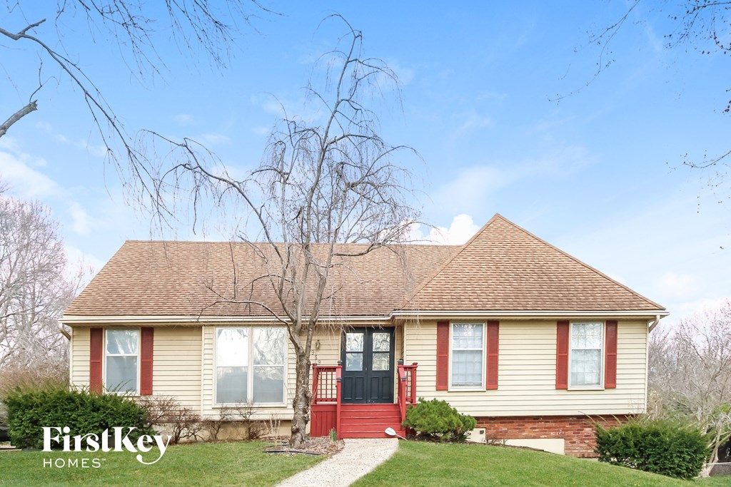 a yellow house with red doors and a brown roof