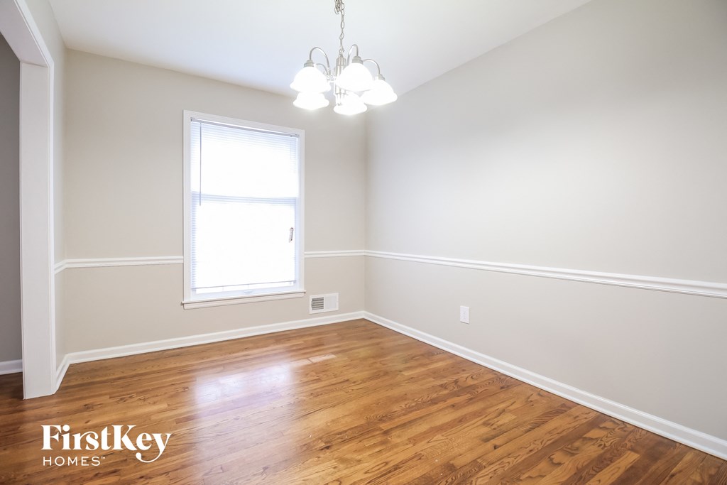 a bedroom with wood flooring and a window and a chandelier