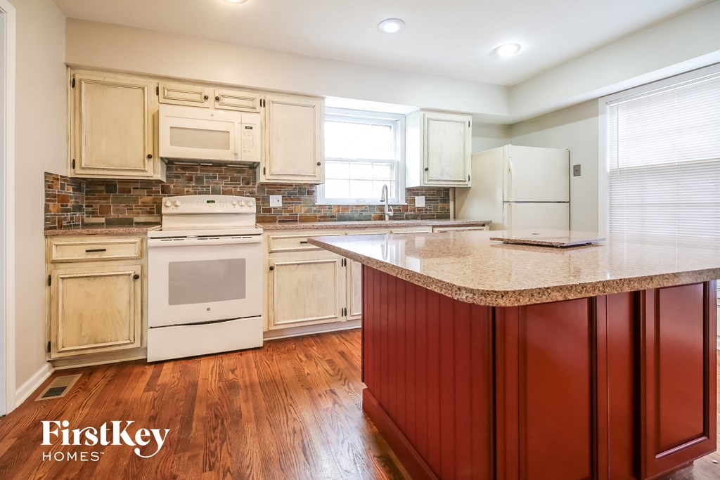 a kitchen with white appliances and a granite counter top
