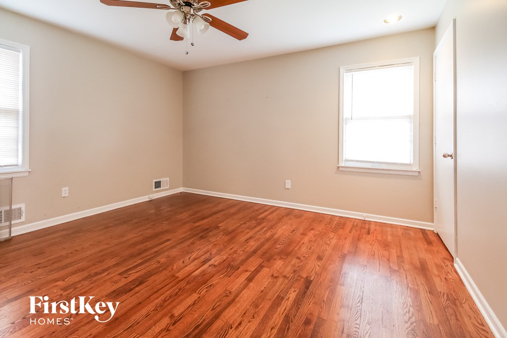 the living room of a home with wood flooring and a ceiling fan