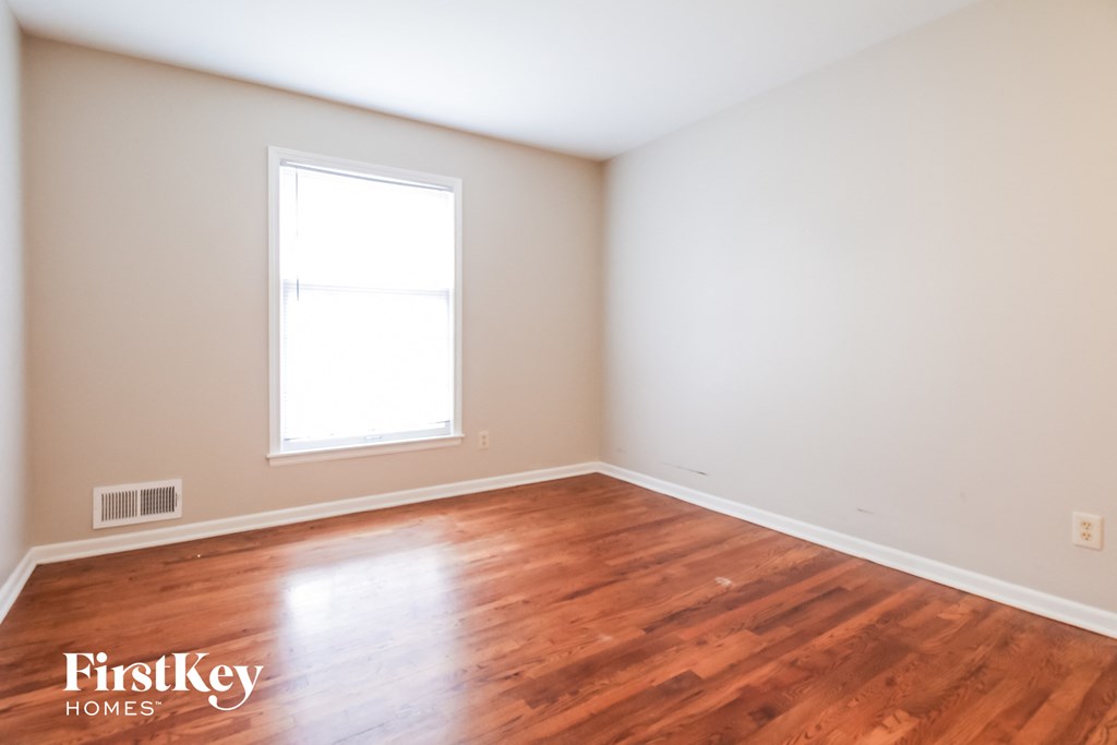 the living room of a home with wood floors and a window