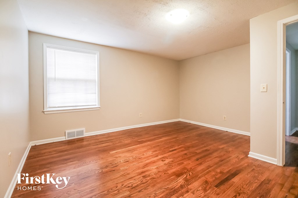 a living room with a hardwood floor and a window