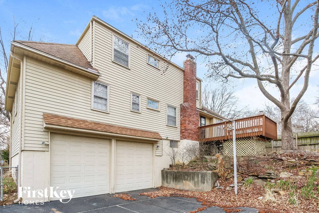 a home with two garage doors and a deck on the side