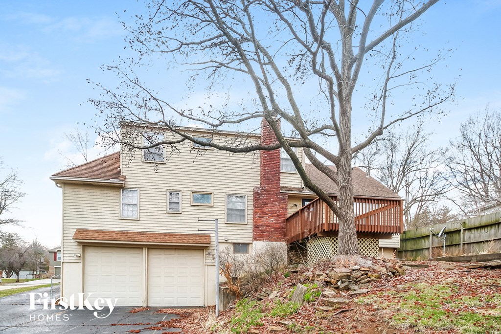 a house with two garage doors and a tree in front of it