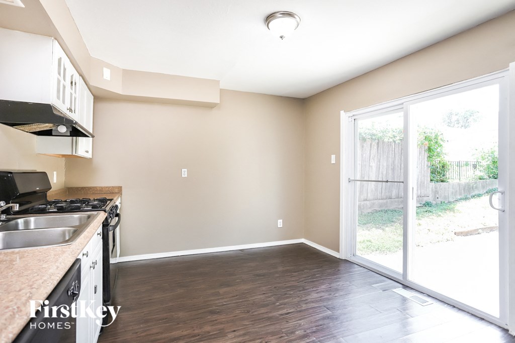 an empty kitchen and living room with a sliding glass door