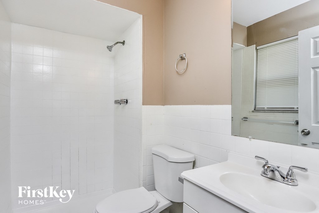 a bathroom with a toilet and a sink and a mirror