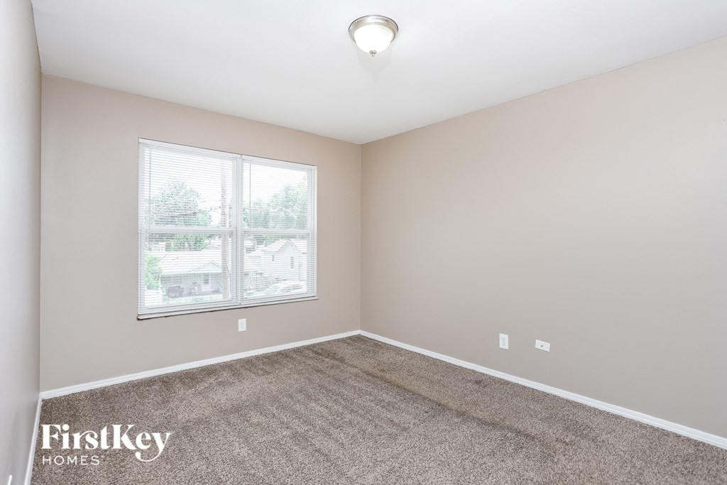 an empty room with carpet and a window