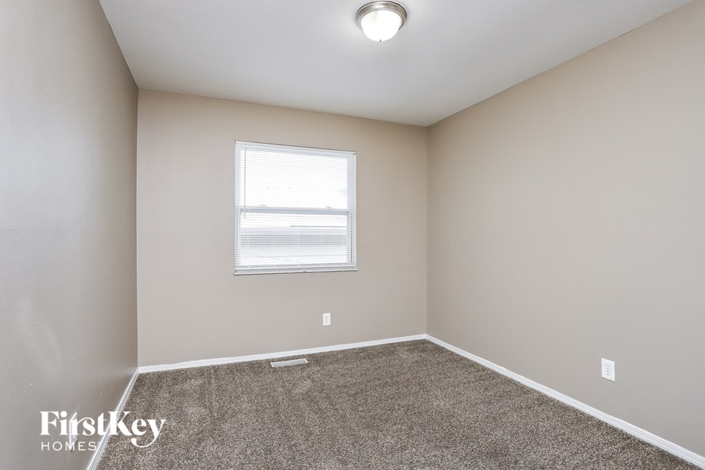 an empty room with carpet and a window