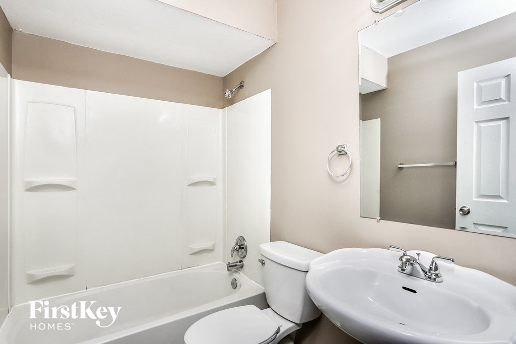 a white bathroom with a sink toilet and bath tub