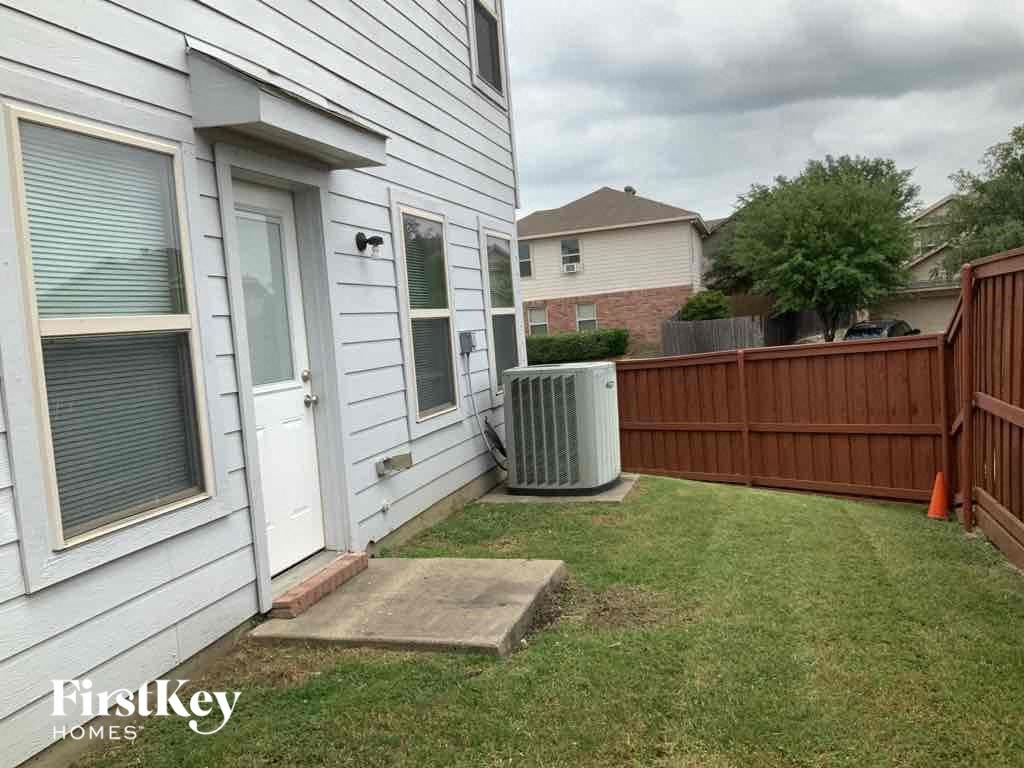 the side of a house with a yard and a fence