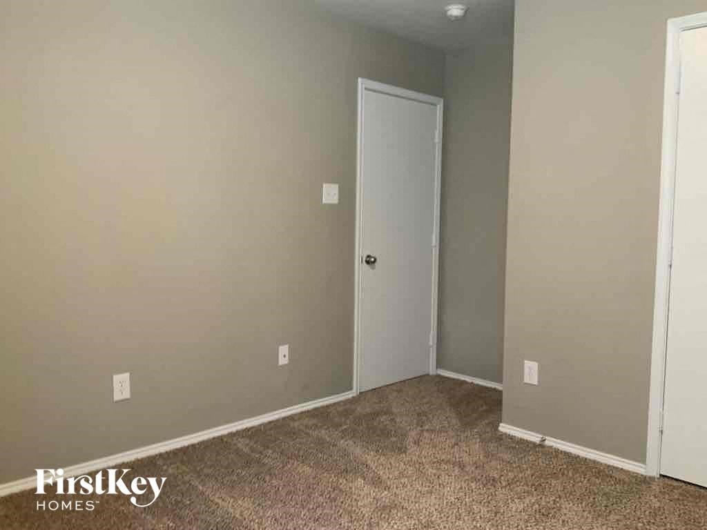 an empty living room with a door to a closet
