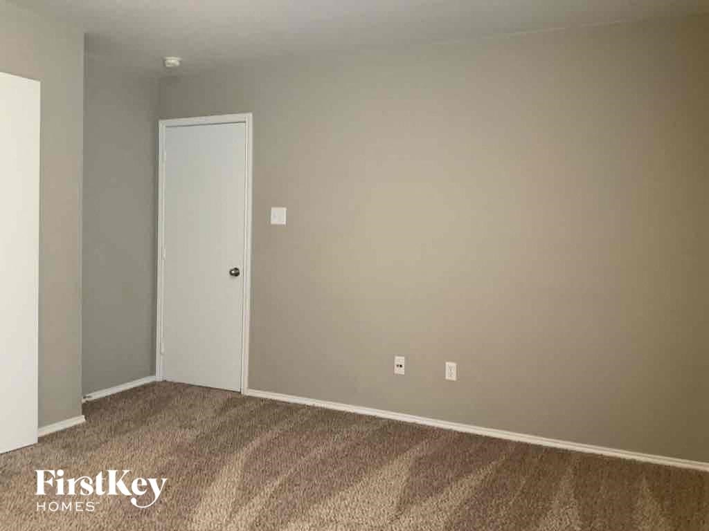 a bedroom with a door and a carpeted floor