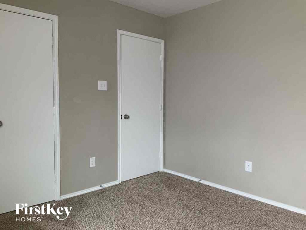 an empty bedroom with a closet and a door
