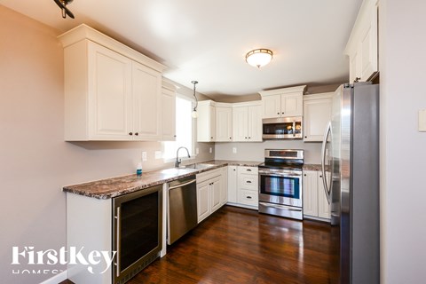 a kitchen with white cabinets and stainless steel appliances
