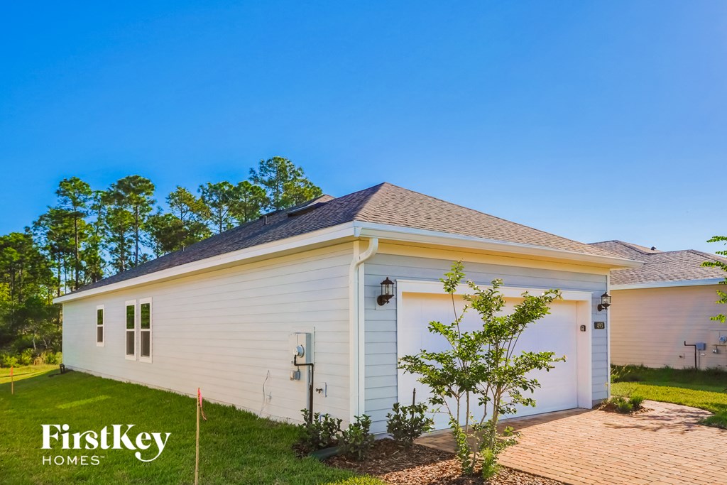 a small white house with a garage and a driveway
