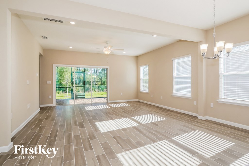 an empty living room with a sliding glass door to the backyard