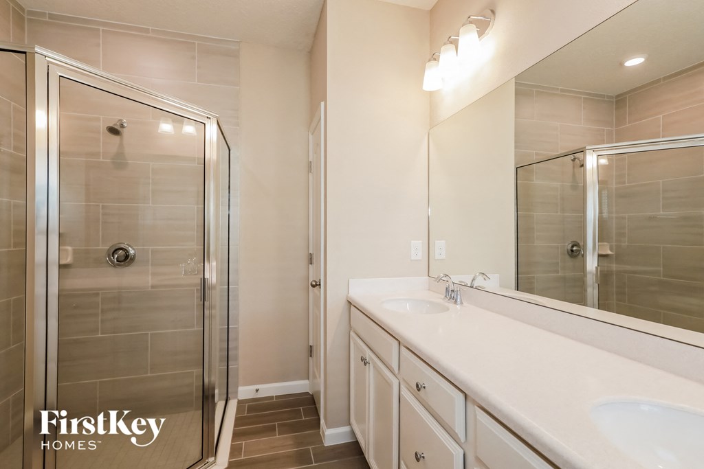 a bathroom with a sink and a shower and a mirror