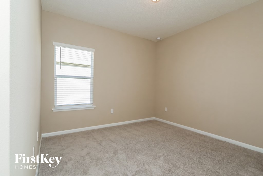 a bedroom with a carpeted floor and a window
