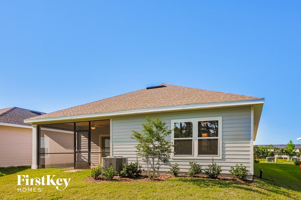 a small white house with a lawn and a blue sky