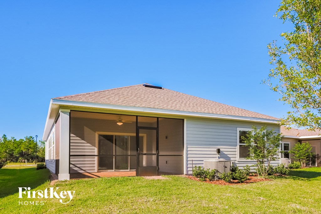 a small gray house with a porch and a lawn