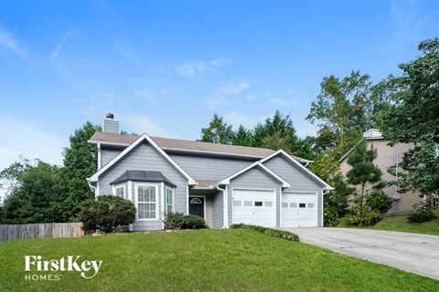 A house with a grey roof and a white garage door is shown.