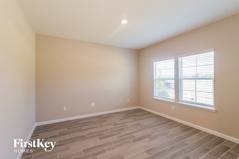 the spacious living room with tile flooring and two windows