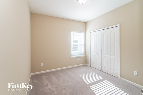 a bedroom with a white door and a carpeted floor